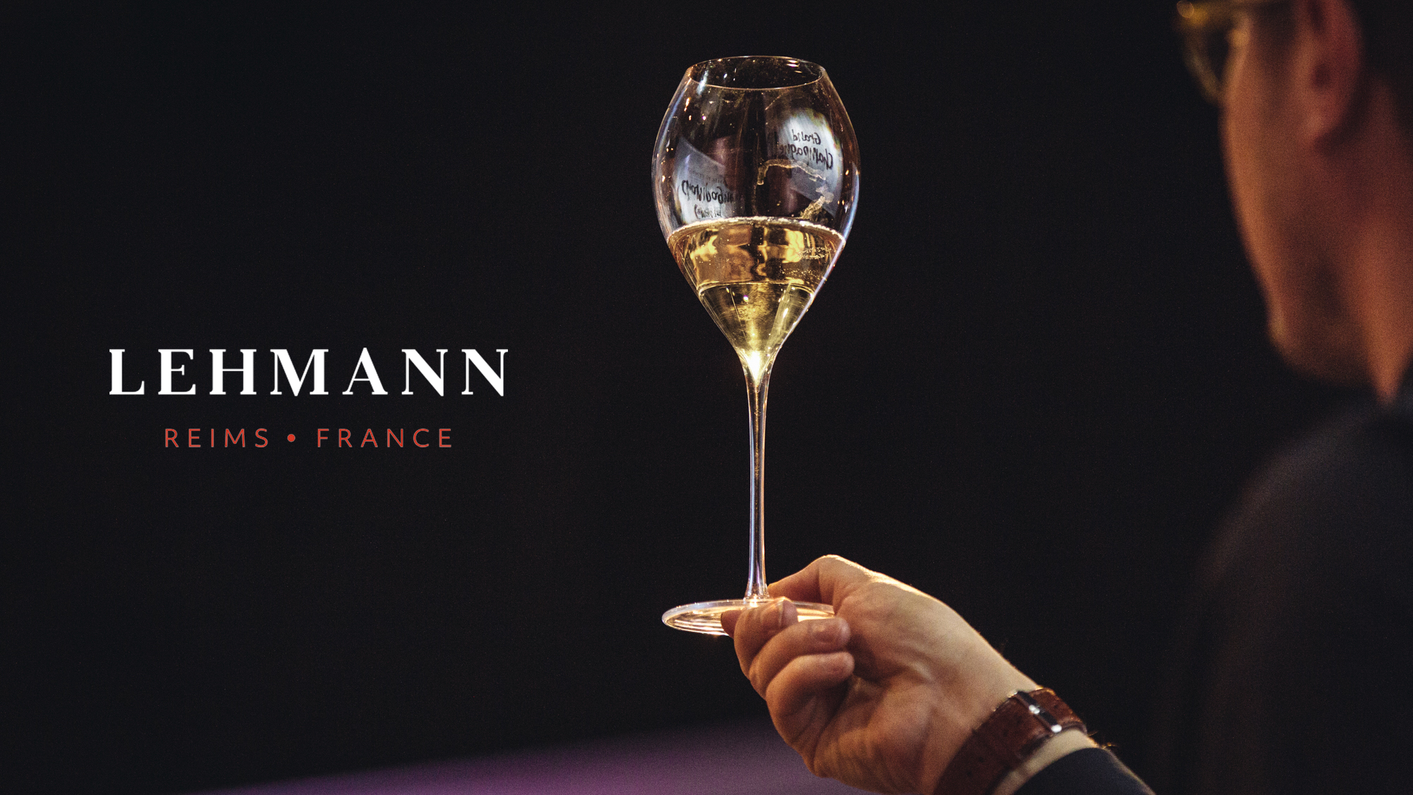 Lehmann Reims Grand Champagne Glass in black background and reflection of Grand Champagne event logo.